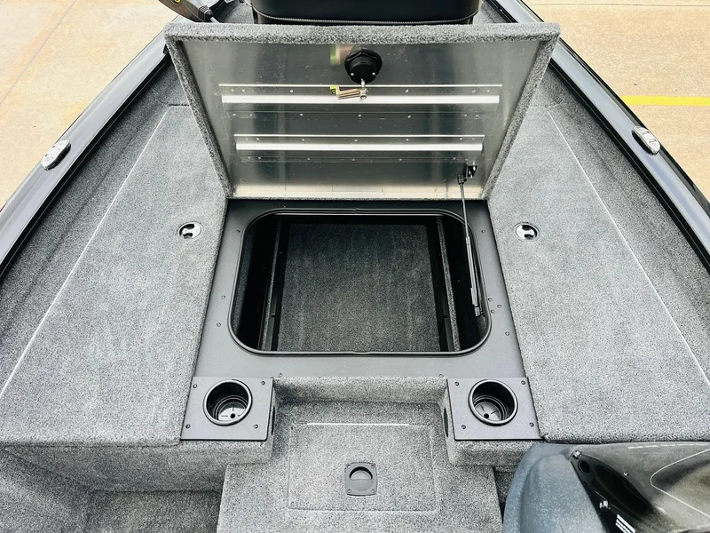 Slide: The Image of 2026 Tracker Pro Team 175 boat interior with open storage compartment and cup holders. - 13