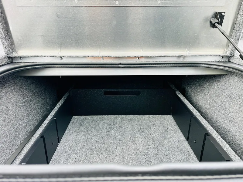 Slide: The Image of Open storage compartment of 2026 Tracker Pro Team 175 boat, featuring carpeted interior. - 14