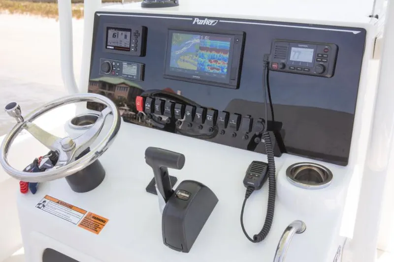 Slide: The Image of Manufacturer Provided Image: 2025 Parker 23SE Center Console boat dashboard with steering wheel, controls, and navigation equipment. - 7