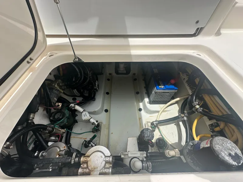 Slide: The Image of 2009 Pursuit C 310 Center Console engine compartment with battery and wiring. - 13