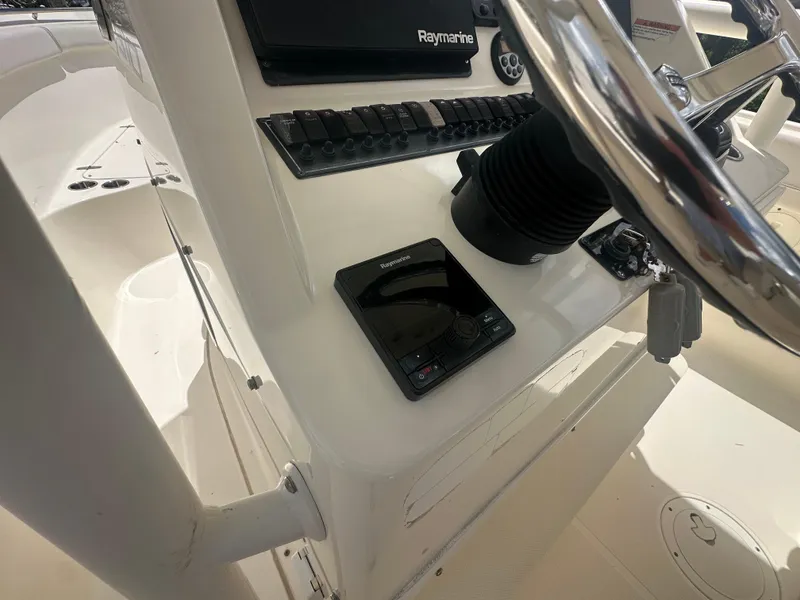 Slide: The Image of 2009 Pursuit C 310 Center Console boat dashboard with Raymarine electronics and steering wheel. - 14
