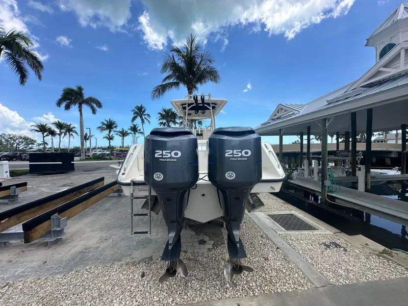 Slide: The Image of 2009 Pursuit C 310 Center Console boat with twin 250 horsepower engines docked under blue sky. - 3