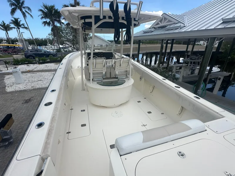 Slide: The Image of 2009 Pursuit C 310 Center Console boat docked, featuring spacious deck and seating. - 7