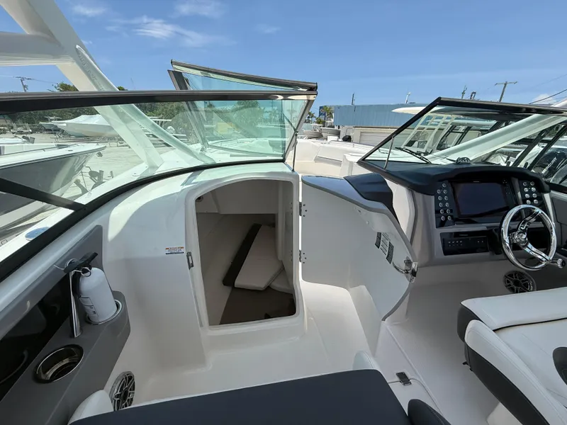 Slide: The Image of 2024 Robalo R317 Dual Console boat interior with helm and cabin entrance. - 12