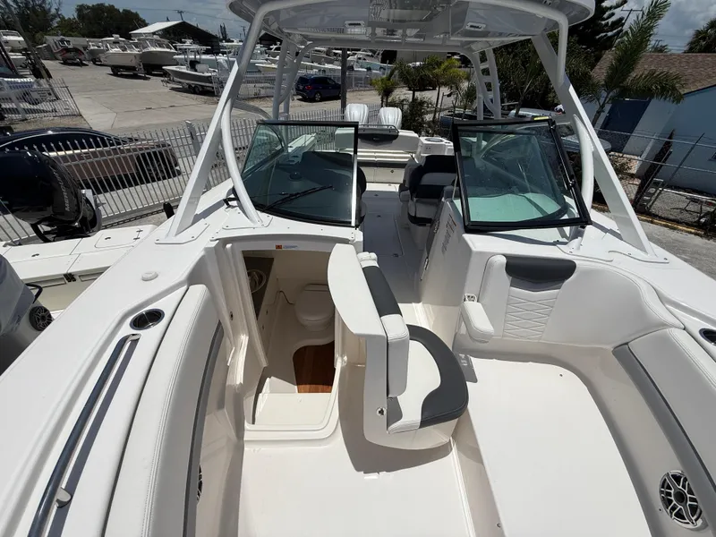 Slide: The Image of 2024 Robalo R317 Dual Console boat interior with seating and helm, docked outdoors. - 15