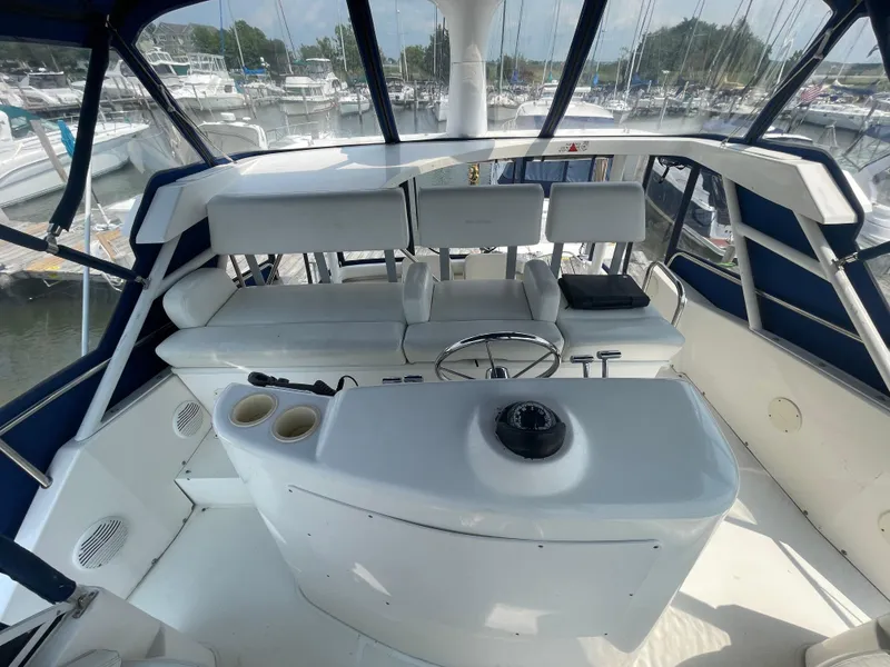 Slide: The Image of 1998 Silverton 322 Motor Yacht helm with seating, docked at marina. - 5