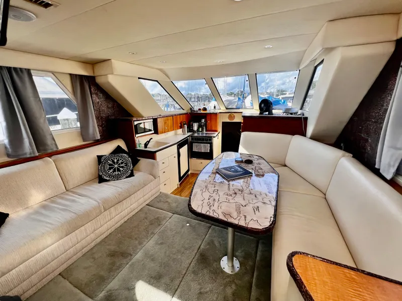 Slide: The Image of Interior of 1998 Silverton 322 Motor Yacht with cozy seating and kitchenette. - 8