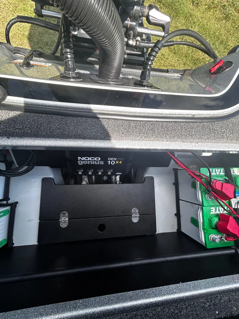 Slide: The Image of 2024 Triton 21XP boat battery compartment with NOCO Genius GENPRO 10X4 charger. - 26