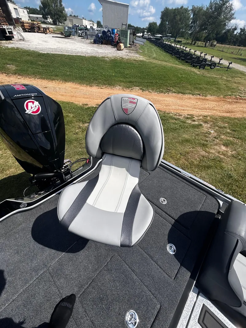 Slide: The Image of 2024 Triton 21XP boat seat with Mercury engine, parked on grass. - 28
