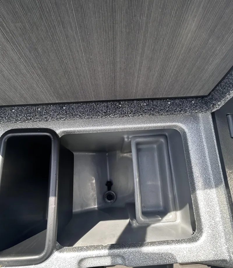 Slide: The Image of 2024 Triton 21XP boat storage compartment with textured interior and drainage. - 3