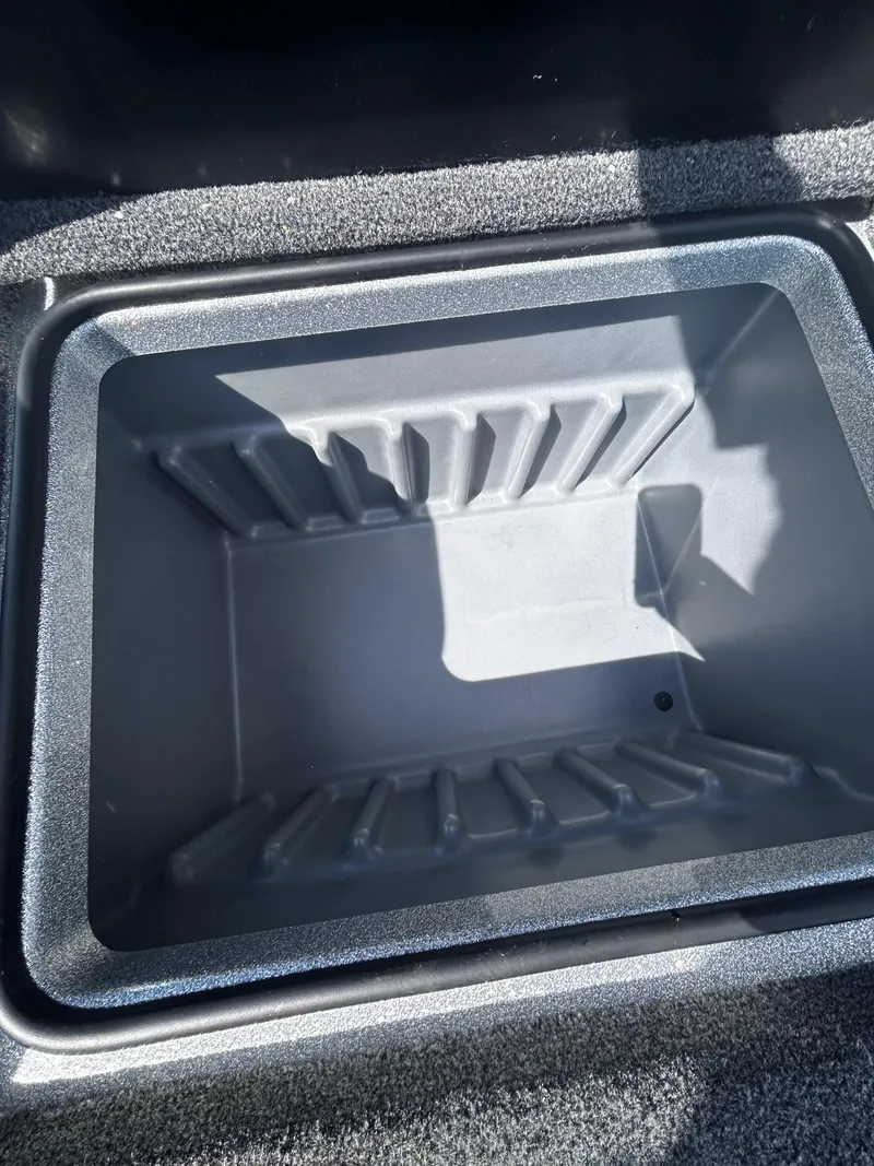 Slide: The Image of 2024 Triton 21XP storage compartment, empty and open, with textured interior. - 31