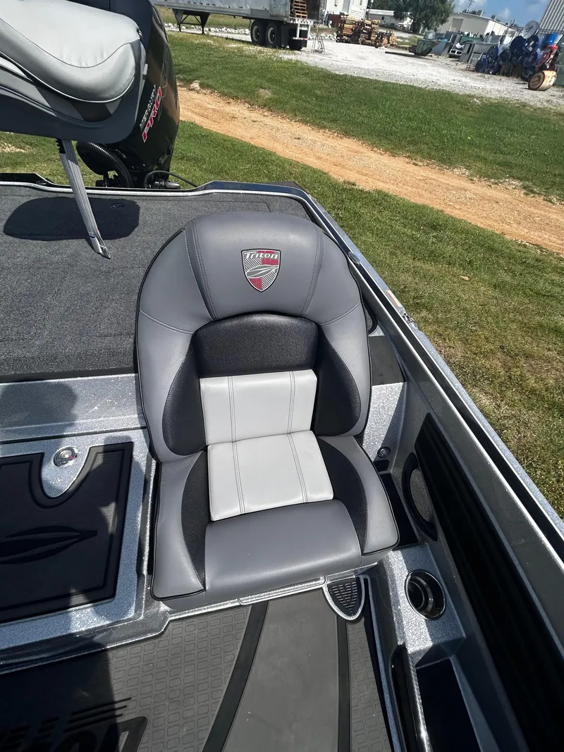 Slide: The Image of 2024 Triton 21XP boat seat with gray and black upholstery, outdoor setting. - 35
