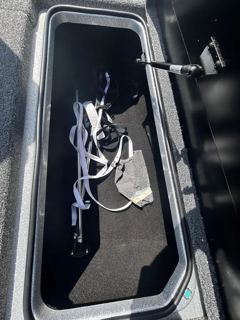 Slide: The Image of Storage compartment of 2024 Triton 21XP boat with straps and equipment inside. - 6