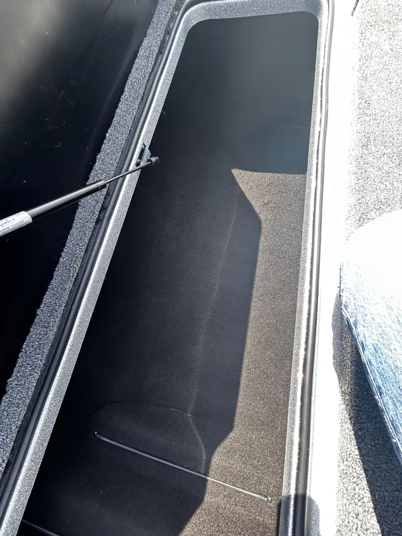 Slide: The Image of 2024 Triton 21XP storage compartment with open lid and hydraulic support. - 7