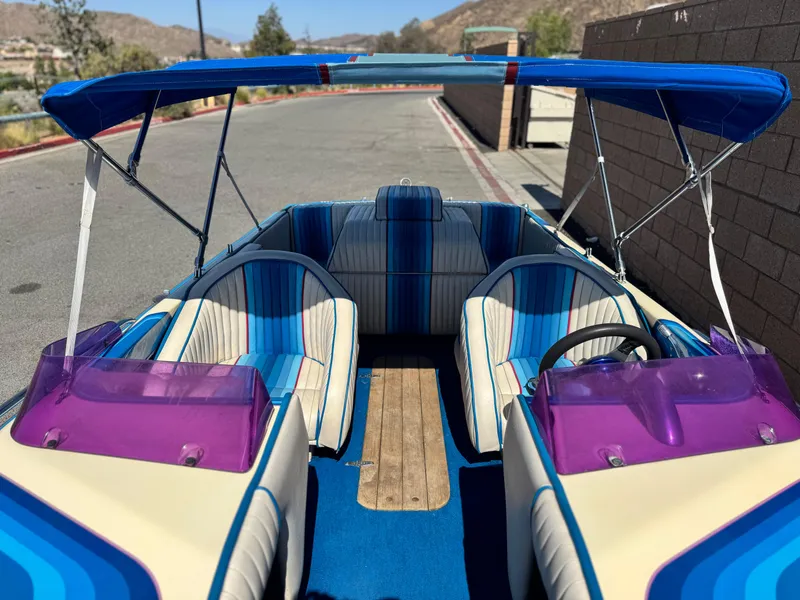 Slide: The Image of 1987 Bahner 19 BR boat interior with blue-striped seats and purple windshields. - 11