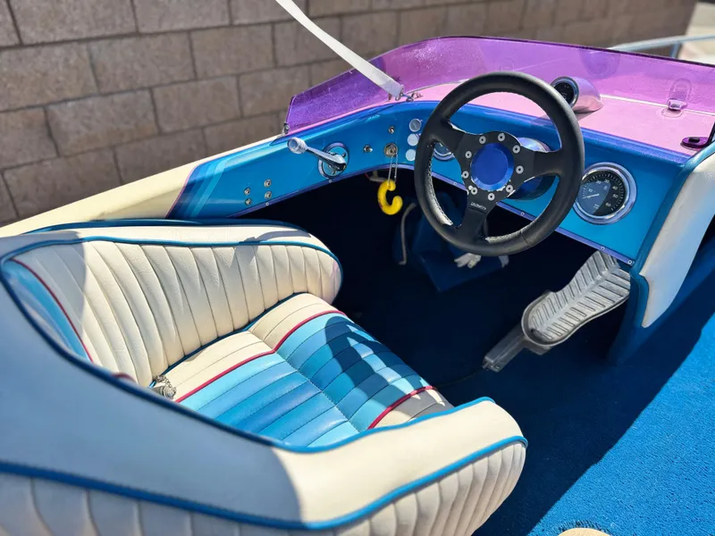 Slide: The Image of Interior of a 1987 Bahner 19 BR boat with blue and white seating. - 17