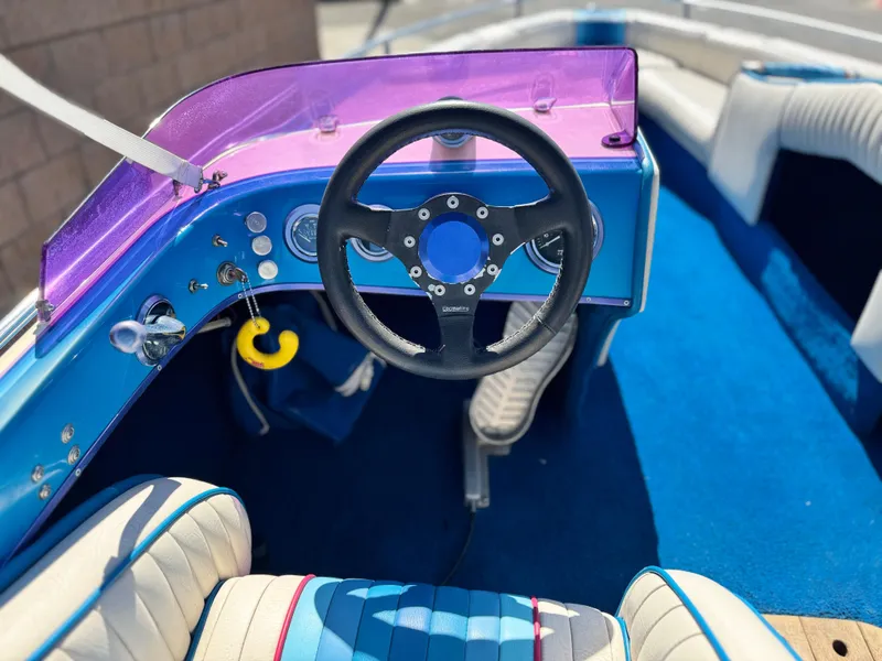 Slide: The Image of Interior of a 1987 Bahner 19 BR boat with blue and purple accents. - 18