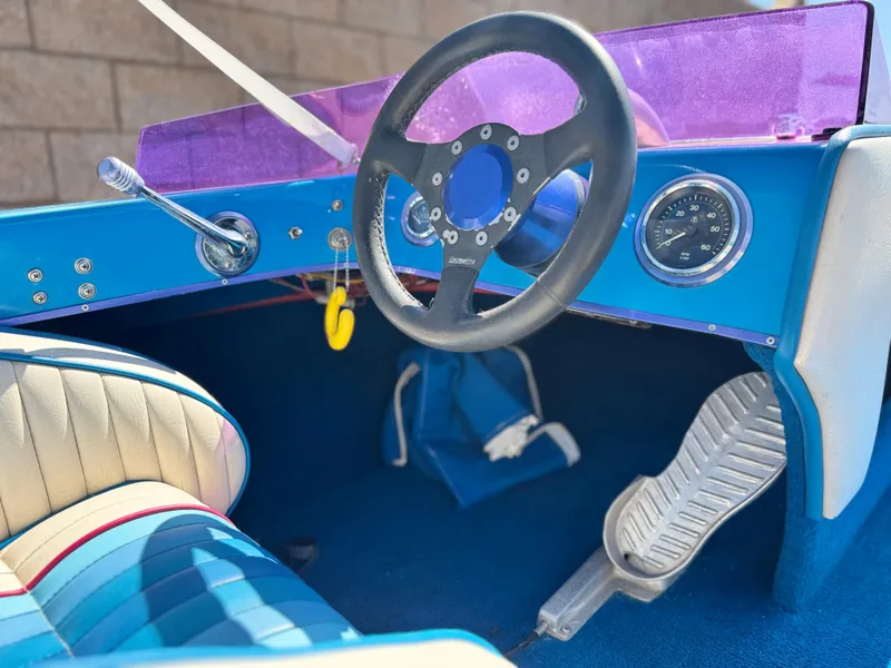 Slide: The Image of Interior of a 1987 Bahner 19 BR boat with blue dashboard and steering wheel. - 19