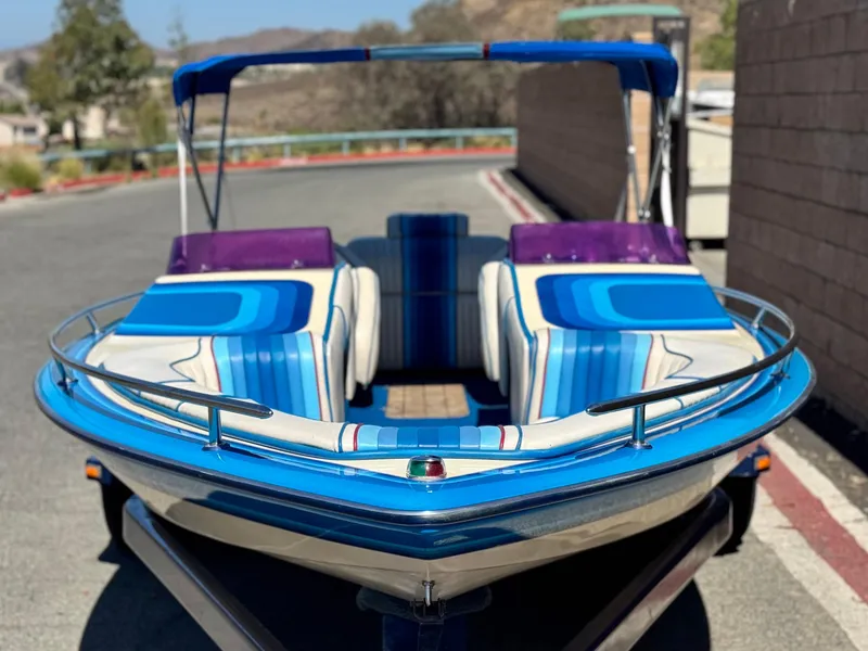 Slide: The Image of 1987 Bahner 19 BR boat with blue and purple upholstery, parked on a trailer. - 2