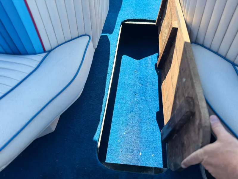 Slide: The Image of 1987 Bahner 19 BR boat interior with blue carpet and storage compartment. - 20