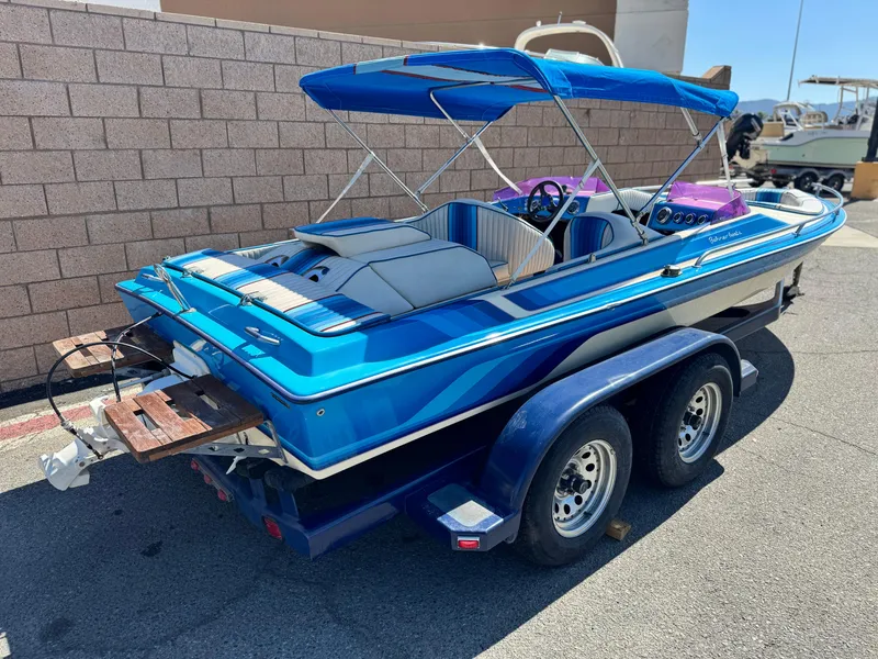 Slide: The Image of 1987 Bahner 19 BR boat with blue canopy on trailer, parked outdoors. - 5