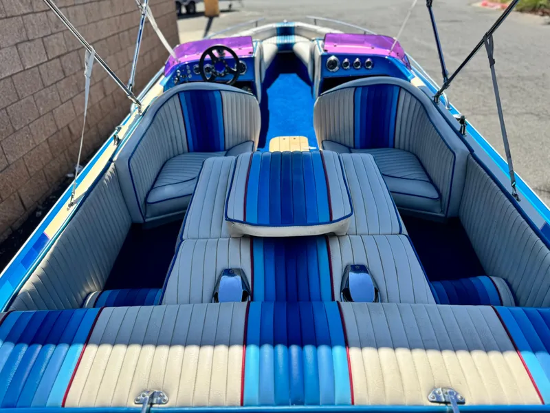 Slide: The Image of 1987 Bahner 19 BR boat interior with blue and white striped seating, steering wheel, and dashboard. - 8