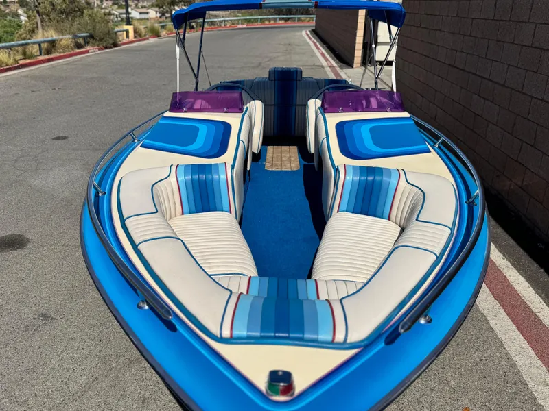 Slide: The Image of 1987 Bahner 19 BR boat with blue and white interior, parked on a road. - 9