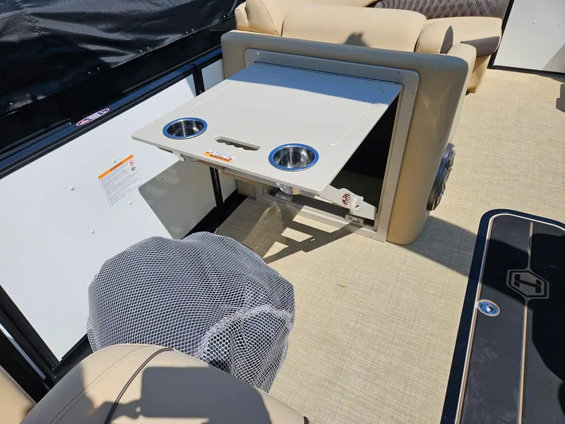 Slide: The Image of 2025 Harris Sunliner 230 boat interior with foldable table and cup holders. - 13