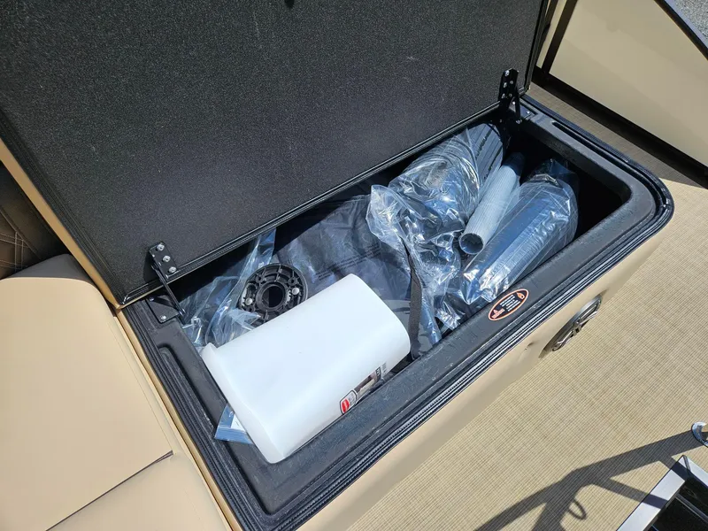 Slide: The Image of Open storage compartment on 2025 Harris Sunliner 230 boat with various items inside. - 17