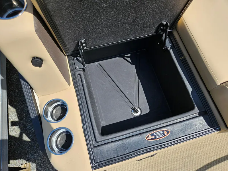 Slide: The Image of Open storage compartment on 2025 Harris Sunliner 230 boat with cup holders. - 20
