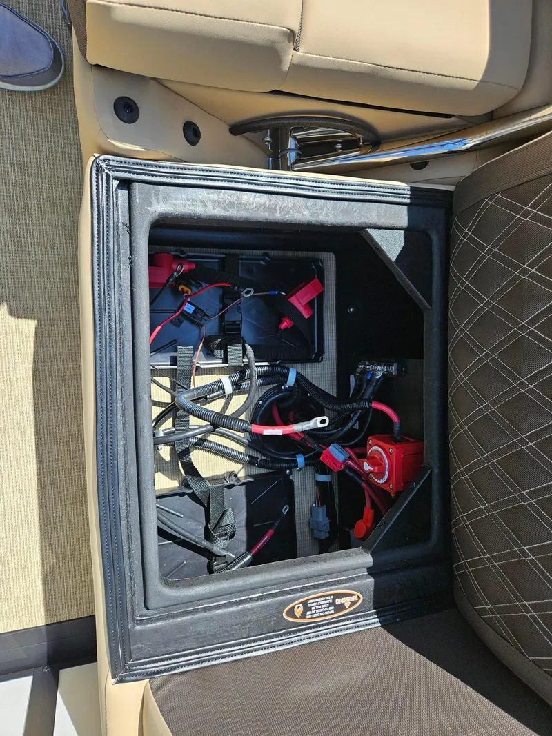 Slide: The Image of Battery compartment of 2025 Harris Sunliner 230 boat, showing wiring and connections. - 21