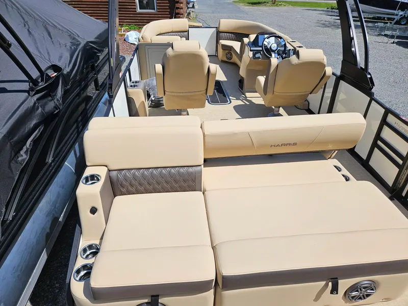 Slide: The Image of 2025 Harris Sunliner 230 boat interior with beige seating and modern steering console. - 5