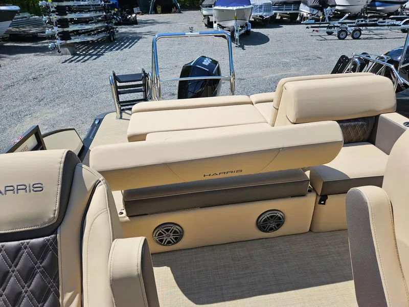 Slide: The Image of 2025 Harris Sunliner 230 boat interior with beige seating and speaker system. - 7