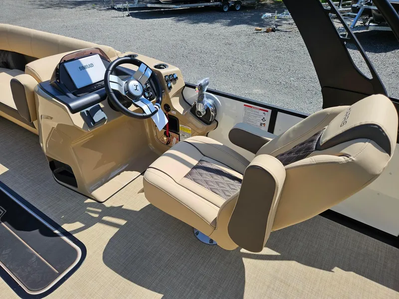 Slide: The Image of 2025 Harris Sunliner 230 boat interior with steering wheel and luxurious captain's chair. - 9