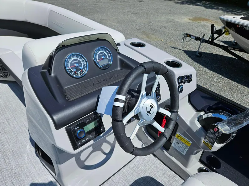 Slide: The Image of 2025 Harris Cruiser 210 boat dashboard with steering wheel and gauges. - 10