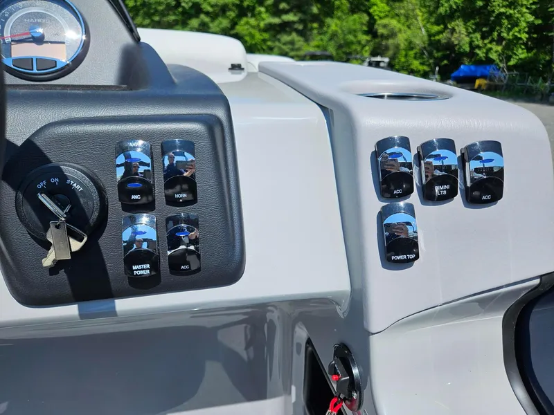Slide: The Image of Control panel of 2025 Harris Cruiser 210 boat with switches and ignition key. - 12