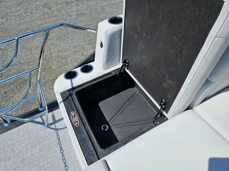 Slide: The Image of Open storage compartment on 2025 Harris Cruiser 210 boat with cup holders. - 17