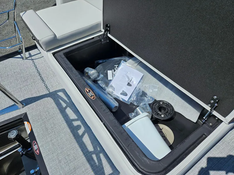 Slide: The Image of Storage compartment of 2025 Harris Cruiser 210 boat with various accessories inside. - 19