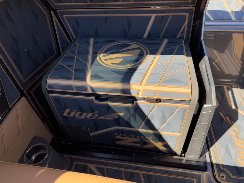Slide: The Image of 2025 Tigé Ultré 25ZX boat interior with stylish geometric design and integrated cooler. - 13