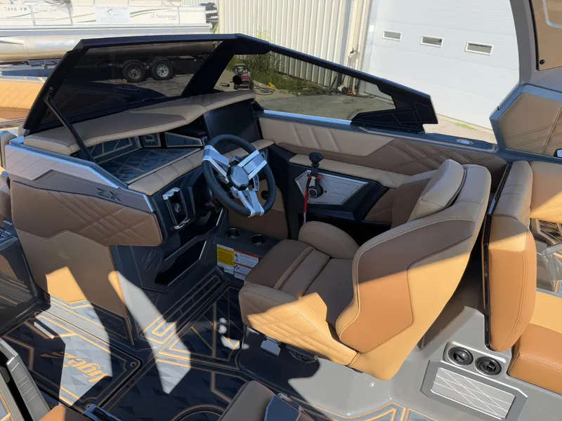 Slide: The Image of 2025 Tigé Ultré 25ZX boat interior with tan leather seats and modern dashboard. - 9