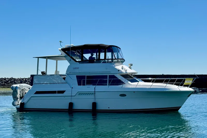 Slide: The Image of 1997 Carver 405 Aft Cabin Motoryacht on calm water, clear sky background. - 1