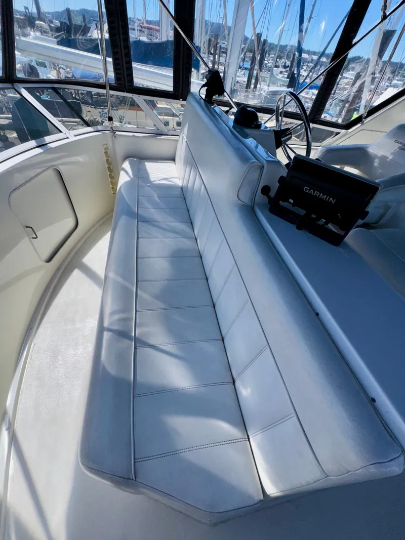 Slide: The Image of 1997 Carver 405 Aft Cabin Motoryacht helm with white seating and Garmin navigation system. - 17