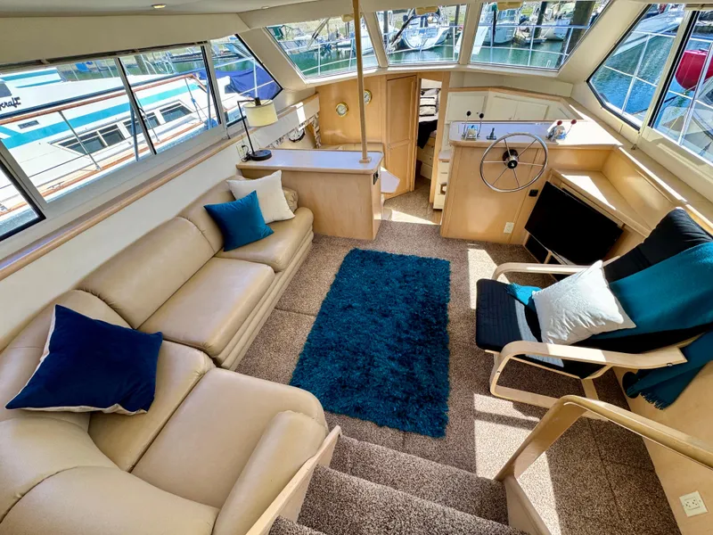 Slide: The Image of Luxurious 1997 Carver 405 Aft Cabin Motoryacht interior with plush seating and nautical decor. - 18
