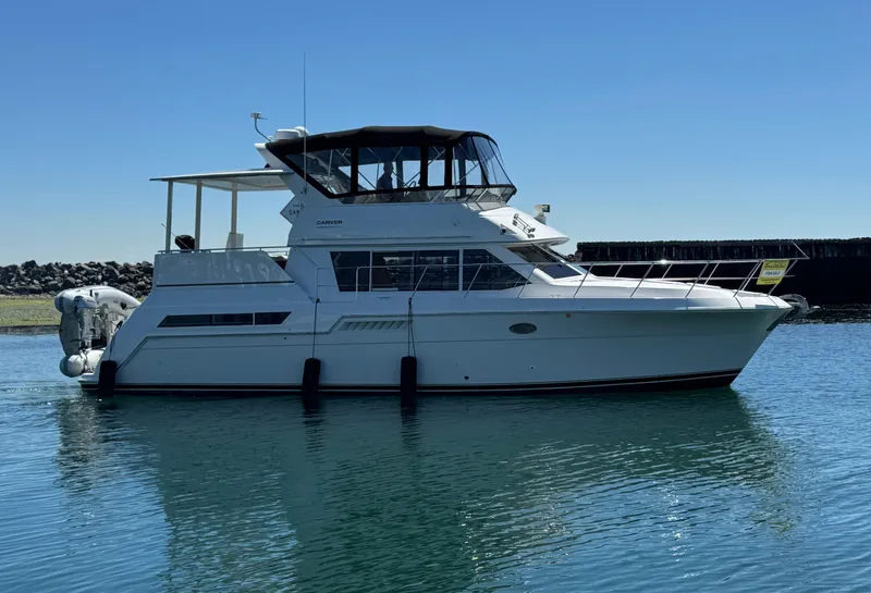 Slide: The Image of 1997 Carver 405 Aft Cabin Motoryacht on calm water, side view. - 2