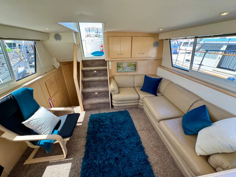 Slide: The Image of Luxurious interior of 1997 Carver 405 Aft Cabin Motoryacht with beige seating and blue accents. - 20