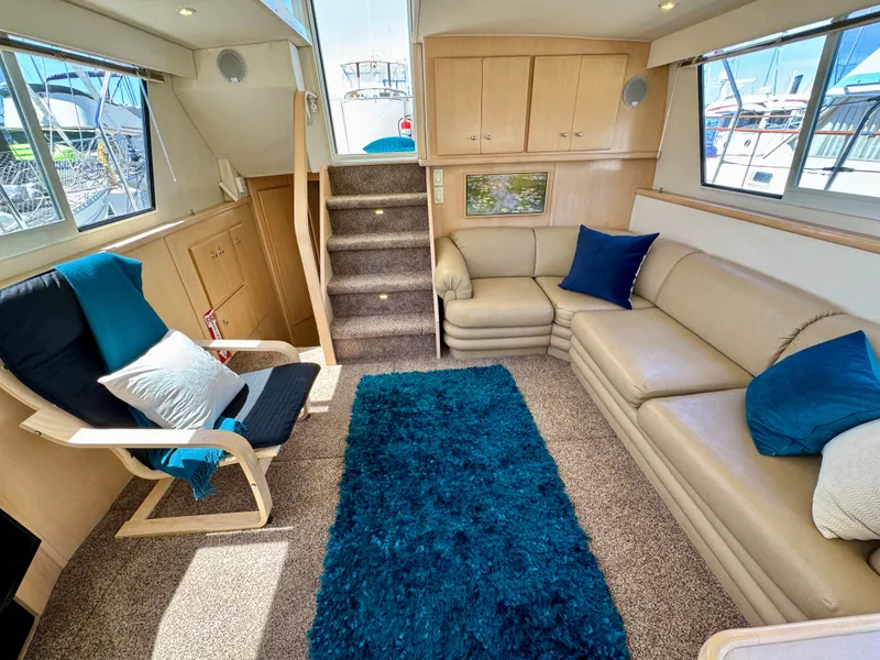 Slide: The Image of Luxurious interior of 1997 Carver 405 Aft Cabin Motoryacht with beige seating and blue accents. - 21