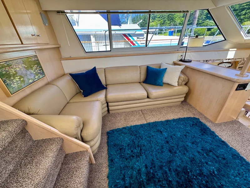 Slide: The Image of Luxurious interior of 1997 Carver 405 Aft Cabin Motoryacht with beige sofa and blue accents. - 22