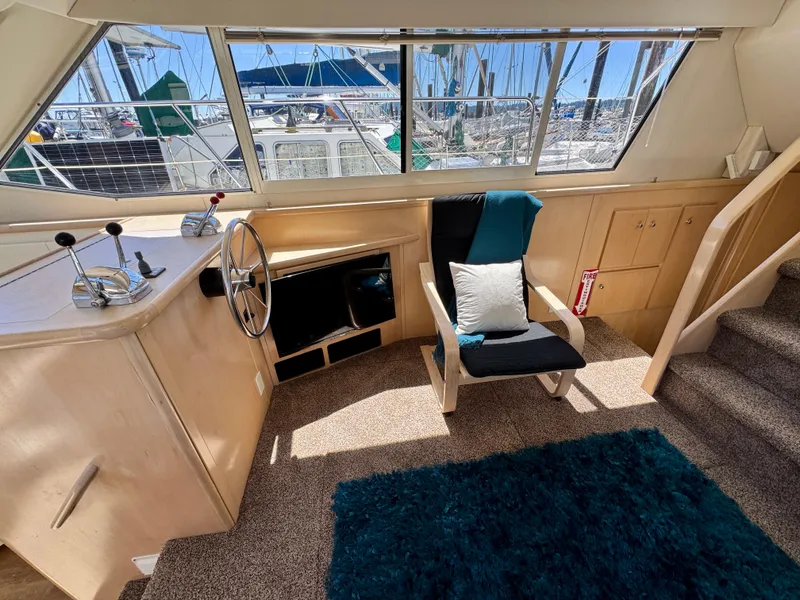 Slide: The Image of 1997 Carver 405 Aft Cabin Motoryacht interior with helm, chair, and nautical decor. - 23