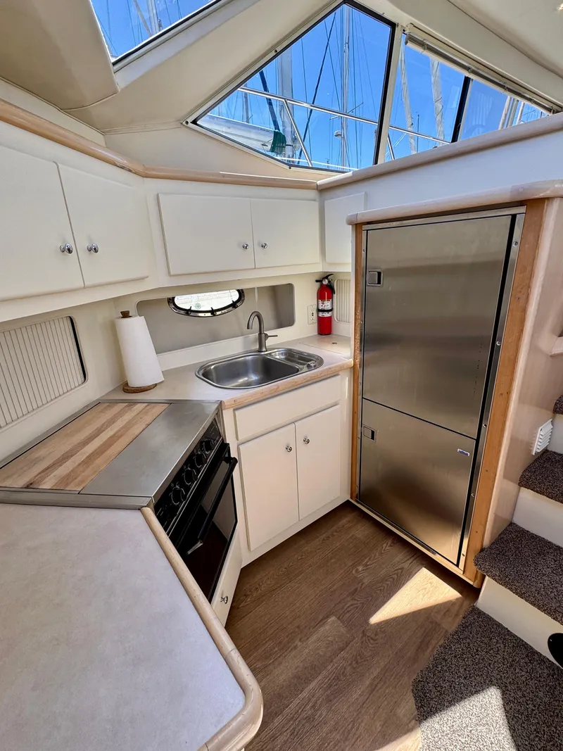 Slide: The Image of 1997 Carver 405 Aft Cabin Motoryacht kitchen with stainless appliances and wood flooring. - 28