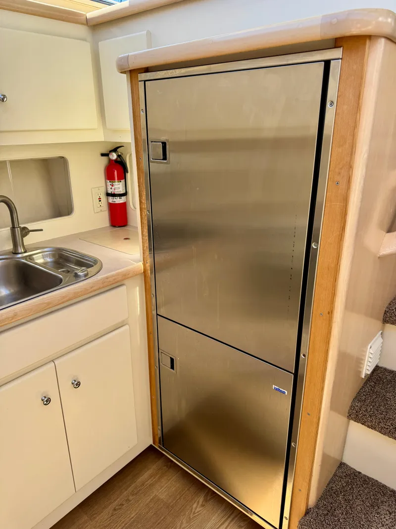 Slide: The Image of 1997 Carver 405 Aft Cabin Motoryacht kitchen with stainless steel fridge and sink. - 30